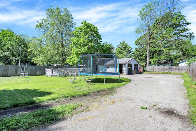 view of yard with an outbuilding and a trampoline