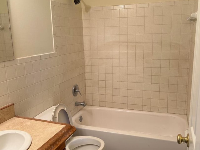 full bathroom featuring tile walls, vanity, toilet, and tiled shower / bath