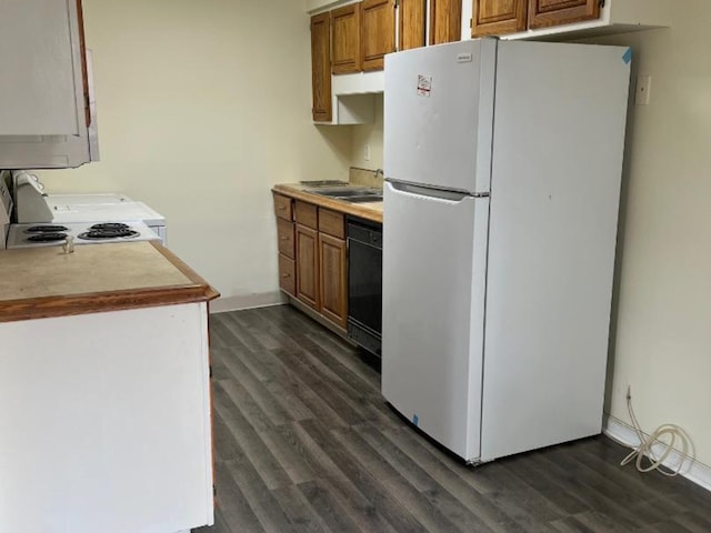 kitchen with white fridge, dark hardwood / wood-style floors, sink, and range