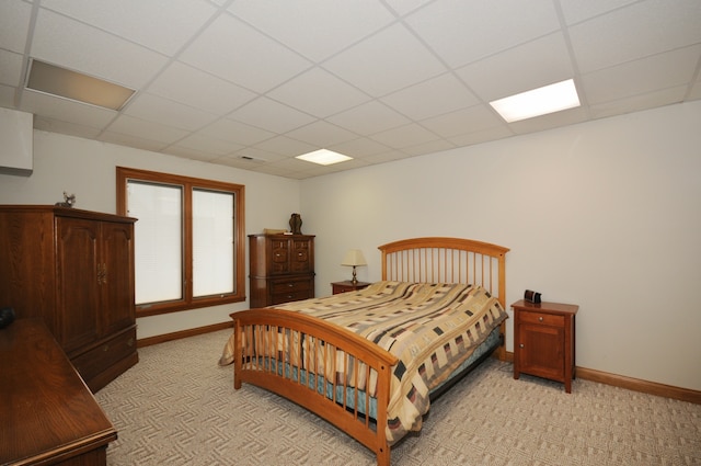 bedroom with light carpet and a drop ceiling