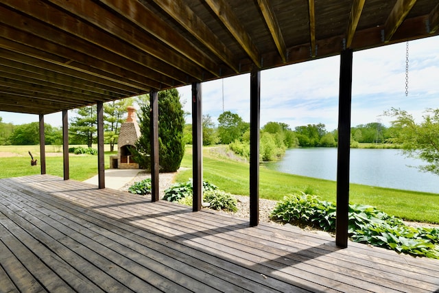 wooden terrace featuring a lawn and a water view