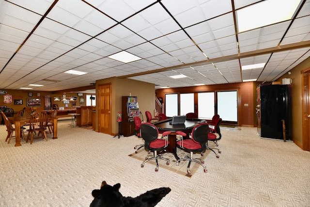 carpeted dining space with a drop ceiling