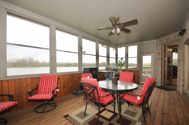 sunroom / solarium with a water view, plenty of natural light, and ceiling fan