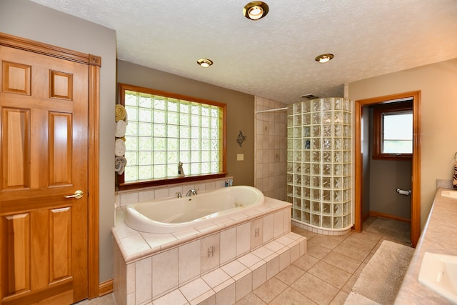 bathroom with tile flooring, plus walk in shower, and a textured ceiling