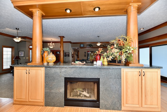 kitchen with light brown cabinets, ceiling fan, a textured ceiling, and decorative columns