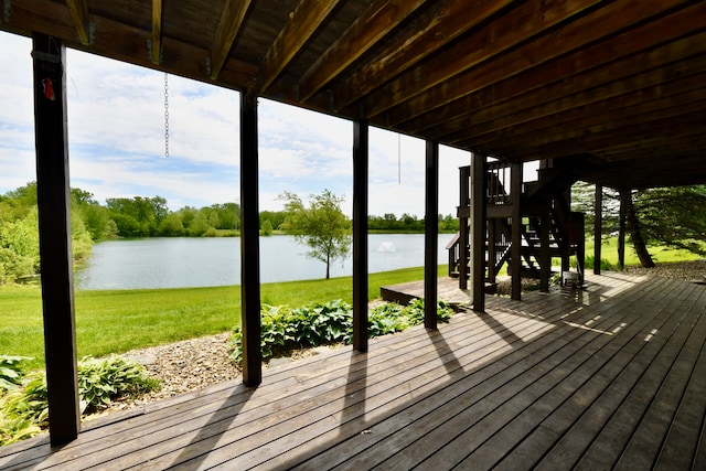 wooden deck with a lawn and a water view