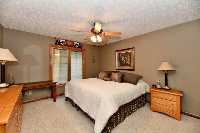 carpeted bedroom featuring a textured ceiling and ceiling fan