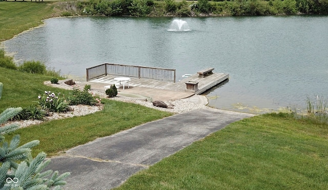 dock area with a lawn and a water view