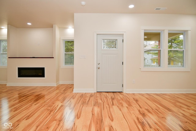 547 Udell St, Indianapolis, IN 46208 - entrance foyer with light wood-style flooring, a glass covered fireplace, baseboards, and recessed lighting