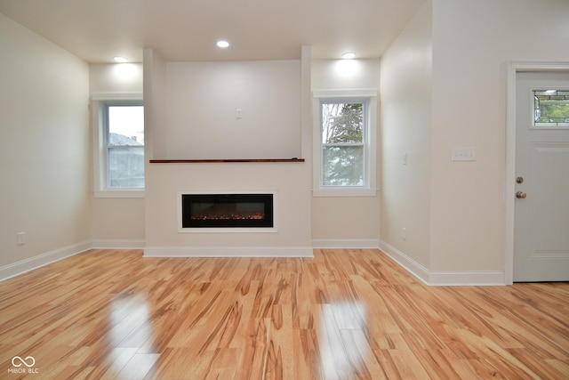 547 Udell St, Indianapolis, IN 46208 - unfurnished living room featuring wood finished floors, healthy amount of natural light, a glass covered fireplace, and recessed lighting