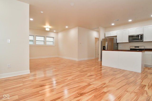 547 Udell St, Indianapolis, IN 46208 - kitchen with appliances with stainless steel finishes, light wood-style flooring, white cabinetry, recessed lighting, and baseboards