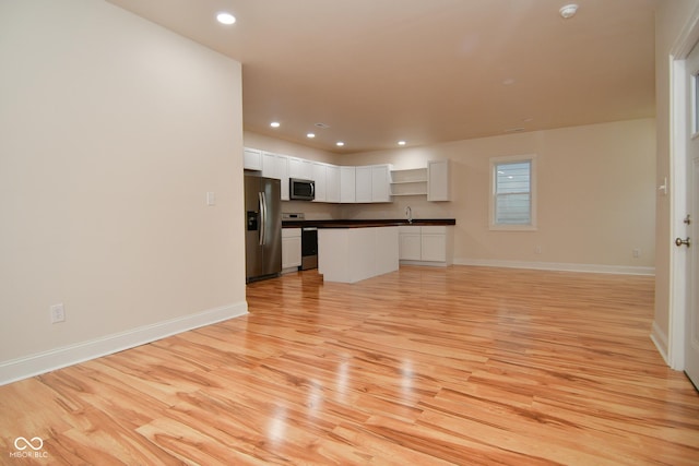 547 Udell St, Indianapolis, IN 46208 - unfurnished living room with light wood finished floors, recessed lighting, a sink, and baseboards