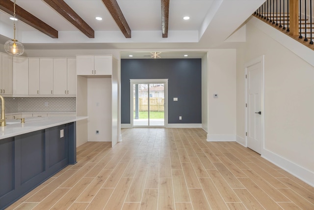 kitchen featuring white cabinets, pendant lighting, light hardwood / wood-style floors, and tasteful backsplash