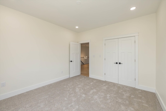 unfurnished bedroom featuring a closet and light carpet