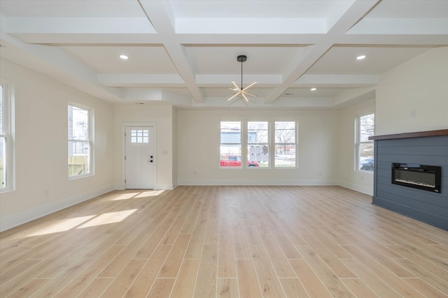 unfurnished living room featuring a notable chandelier, light wood-type flooring, coffered ceiling, and beam ceiling