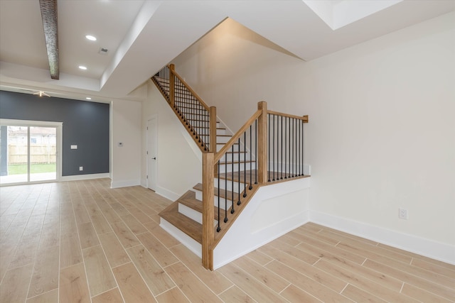 staircase featuring beam ceiling and hardwood / wood-style flooring