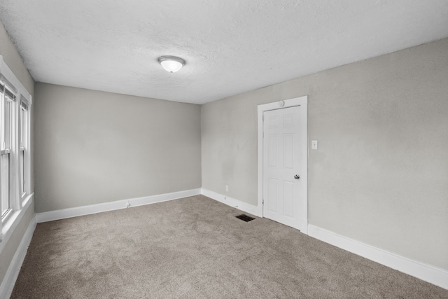 empty room featuring carpet flooring and a textured ceiling