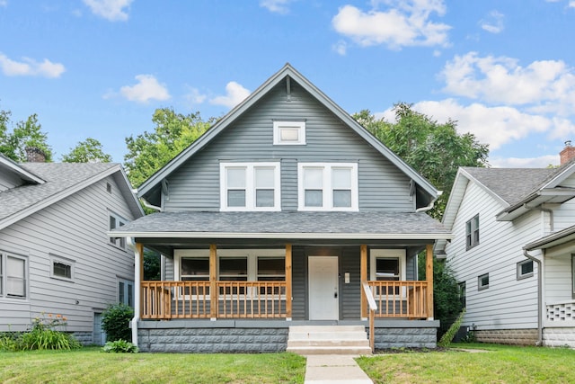 bungalow featuring a porch and a front lawn