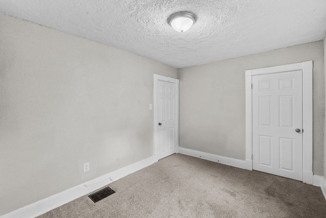 carpeted empty room with a textured ceiling