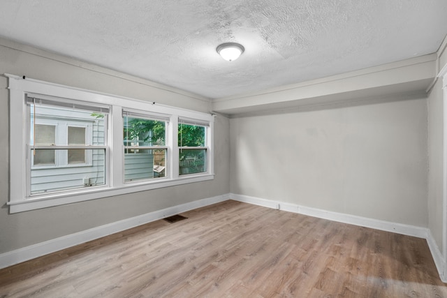 empty room featuring a textured ceiling and hardwood / wood-style flooring