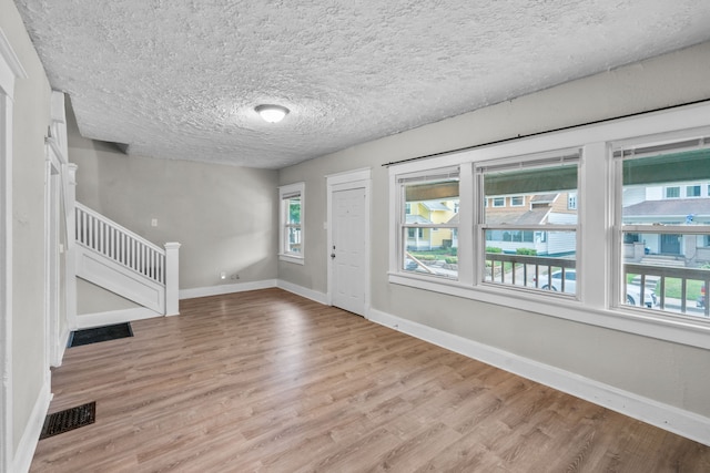 entryway with a textured ceiling and light hardwood / wood-style floors