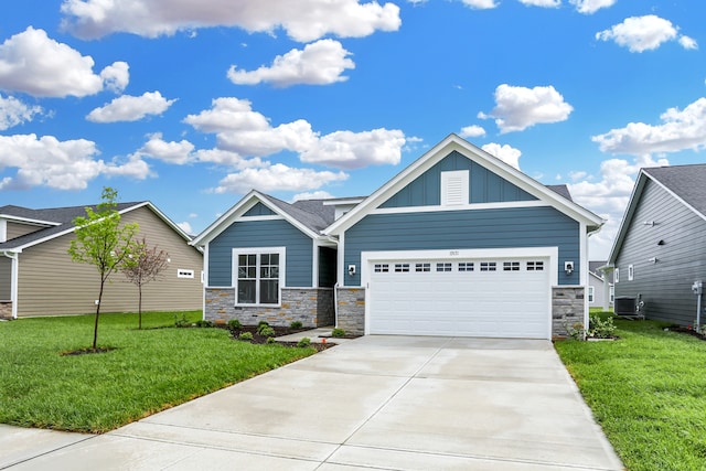 view of front of house featuring a front lawn, a garage, and central AC