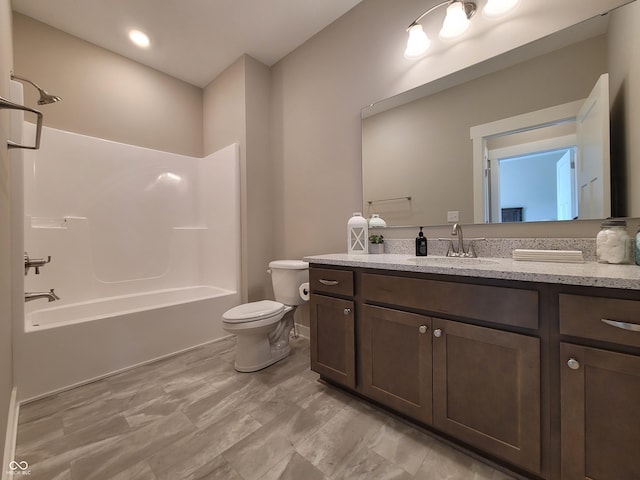 full bathroom with toilet, vanity, and washtub / shower combination