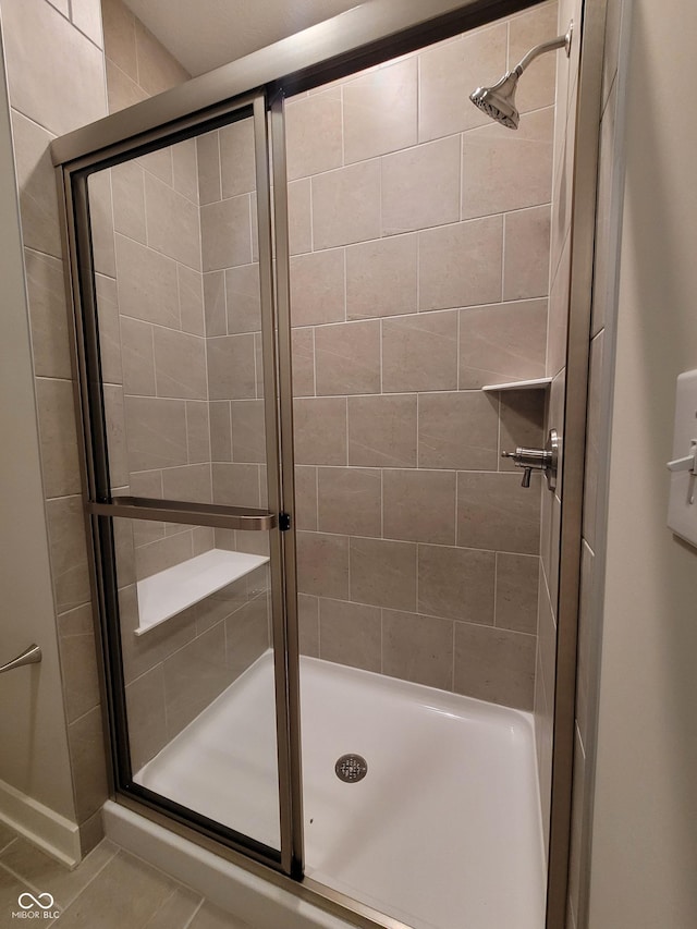 bathroom featuring tile patterned flooring and an enclosed shower