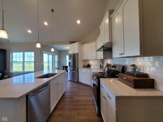 kitchen with light stone countertops, hanging light fixtures, stainless steel appliances, a kitchen island with sink, and white cabinets