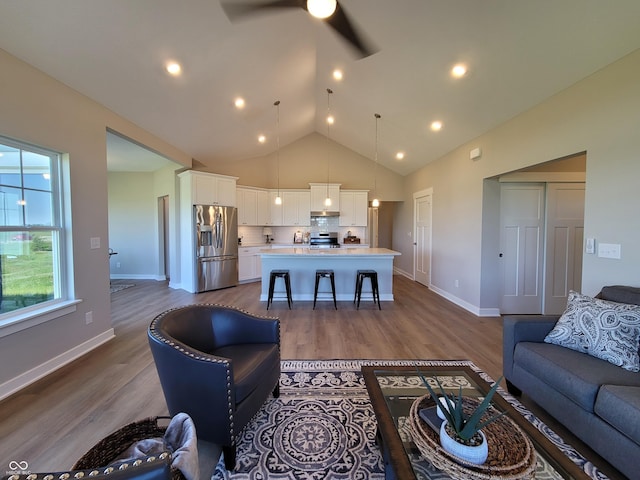 living room with wood-type flooring, ceiling fan, and lofted ceiling