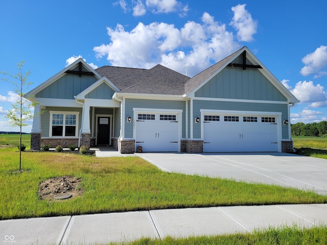 craftsman house with a garage and a front lawn