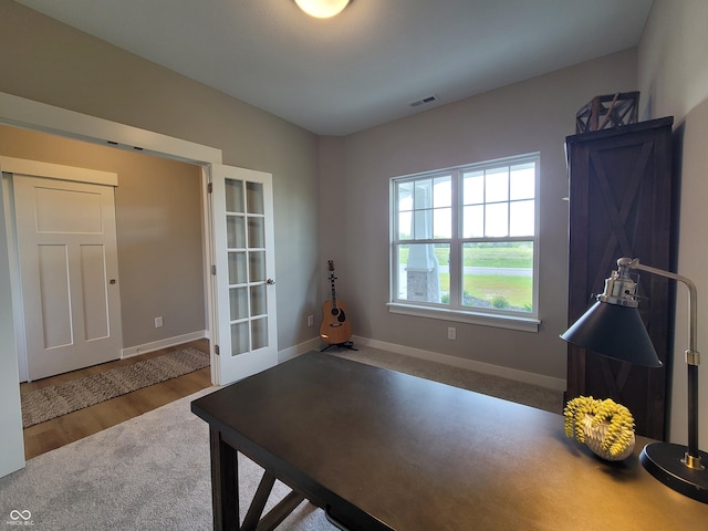 home office with french doors and hardwood / wood-style flooring