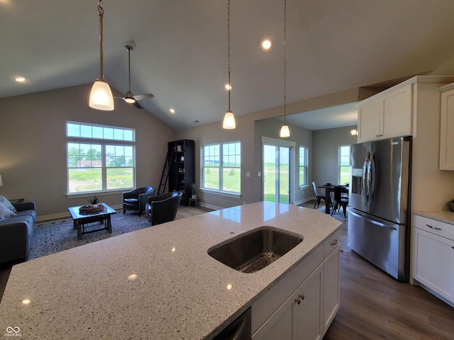 kitchen with light stone countertops, stainless steel refrigerator with ice dispenser, dark wood-type flooring, white cabinets, and lofted ceiling