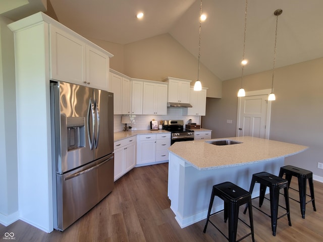 kitchen with white cabinetry, high vaulted ceiling, a kitchen island with sink, appliances with stainless steel finishes, and hardwood / wood-style flooring