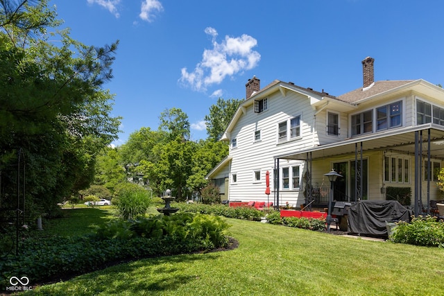 back of property with a lawn