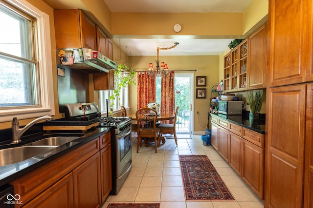 kitchen with light tile patterned flooring, ventilation hood, stainless steel range with gas cooktop, and sink