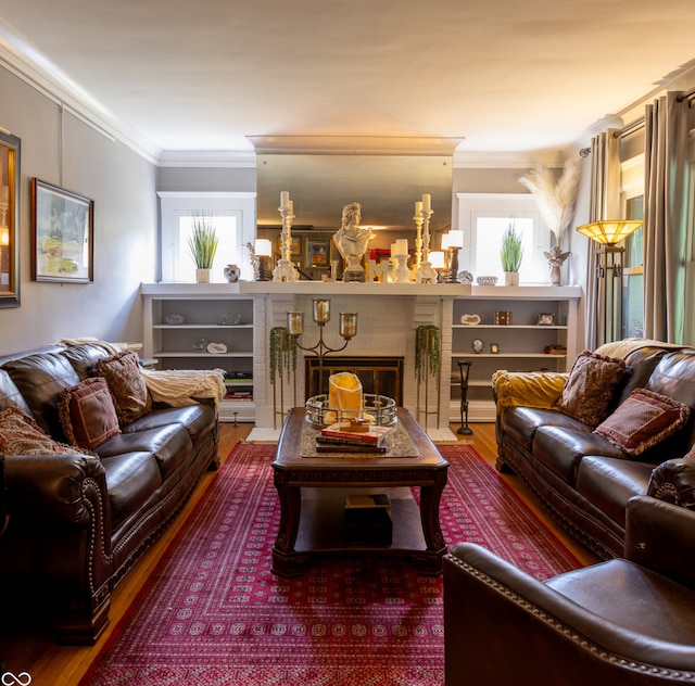 living room featuring a healthy amount of sunlight, a premium fireplace, ornamental molding, and hardwood / wood-style flooring