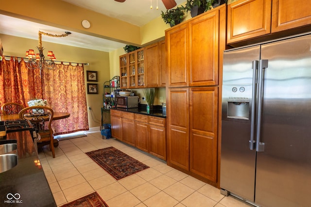 kitchen featuring appliances with stainless steel finishes, ceiling fan with notable chandelier, and light tile patterned flooring