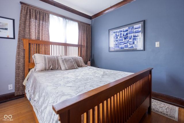 bedroom featuring hardwood / wood-style flooring and crown molding