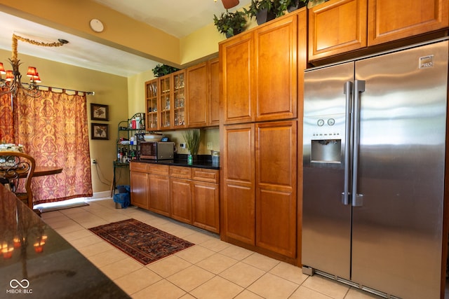 kitchen featuring stainless steel built in fridge, light tile patterned floors, and a notable chandelier