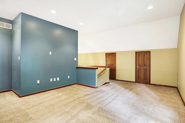 carpeted empty room with vaulted ceiling