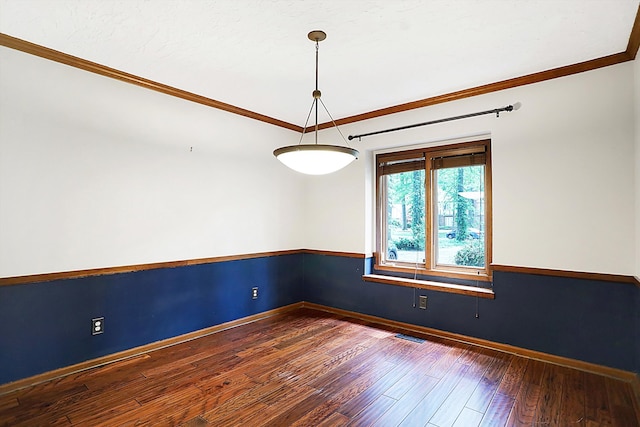 spare room featuring ornamental molding and dark hardwood / wood-style floors