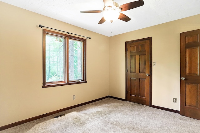 spare room with light colored carpet and ceiling fan