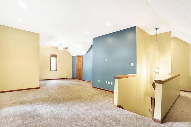 empty room featuring vaulted ceiling, carpet floors, and ceiling fan