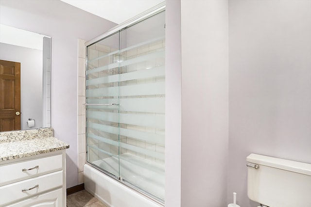 full bathroom with vanity, combined bath / shower with glass door, tile patterned floors, and toilet