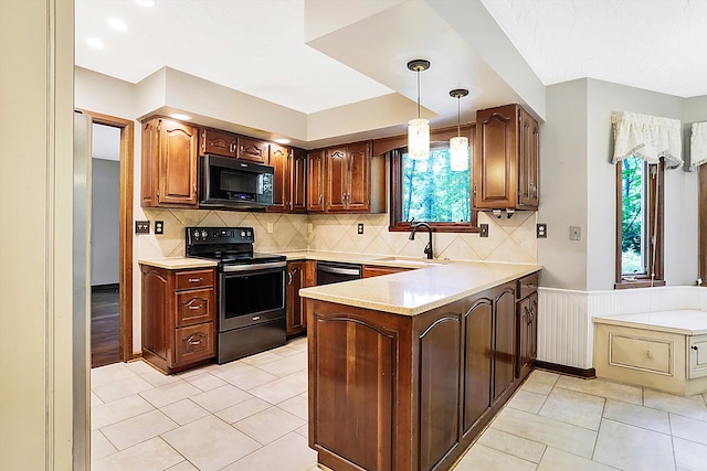 kitchen with sink, tasteful backsplash, decorative light fixtures, kitchen peninsula, and black appliances