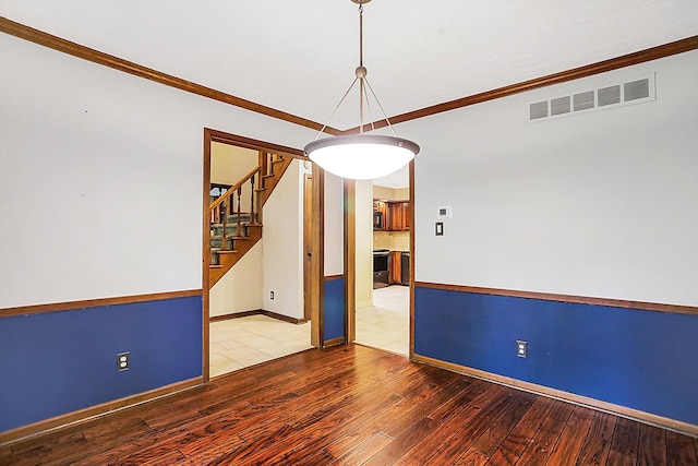 unfurnished room featuring ornamental molding and wood-type flooring