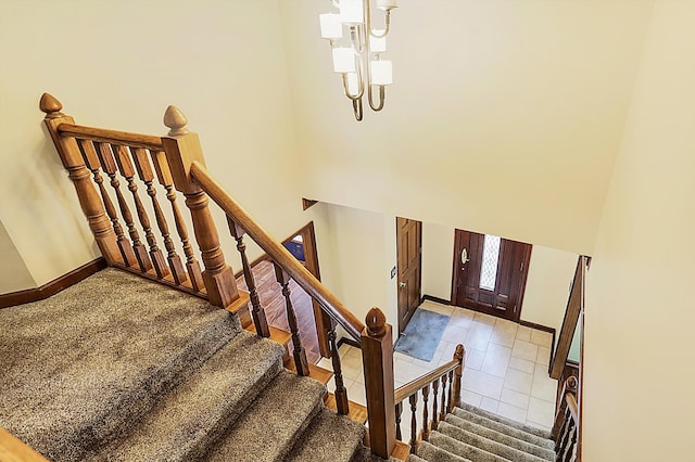 staircase with tile patterned flooring and a high ceiling