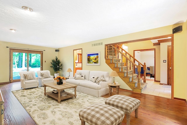 living room featuring a textured ceiling and light hardwood / wood-style flooring