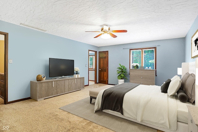 carpeted bedroom featuring ceiling fan and a textured ceiling